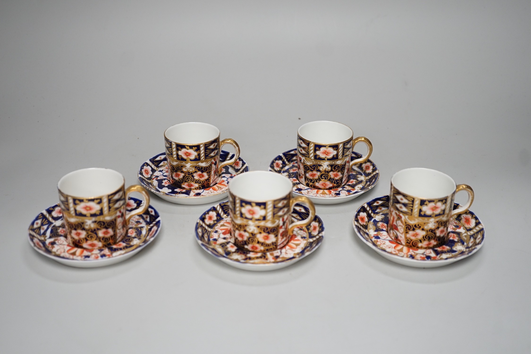 Five Royal Crown Derby Imari coffee cans and saucers